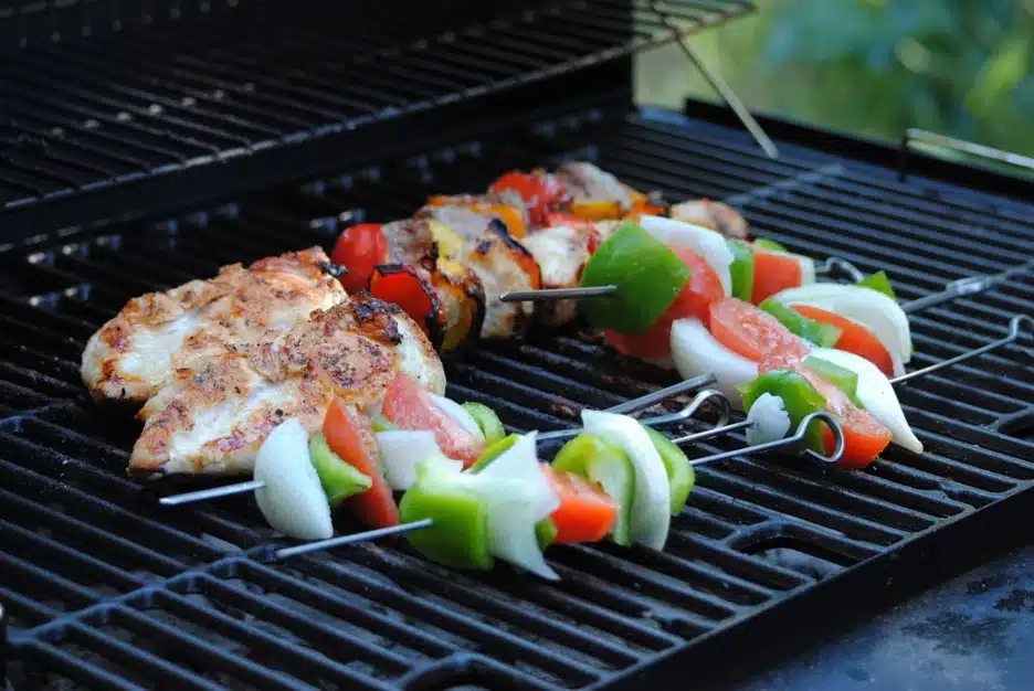 Chicken breast and veggie skewers grilling on a barbecue